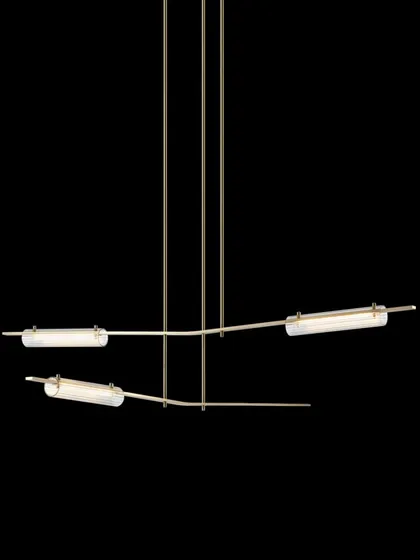 The Volant chandelier with a natural hand-rubbed brass finish and clear textured glass, offering a warmer and brighter aesthetic.