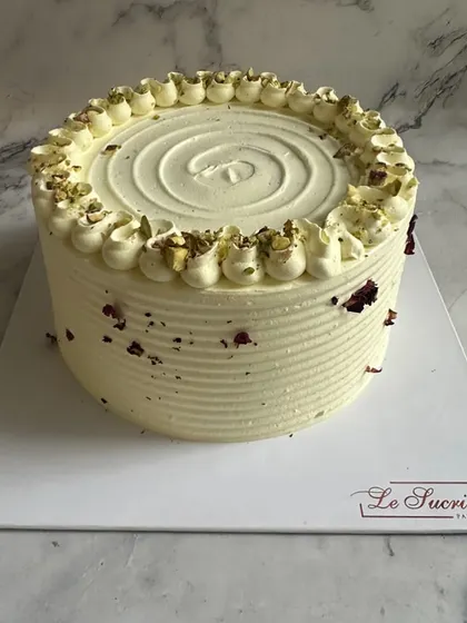My fusion Rasmalai Cake. This unique creation combines the traditional Indian sweet with a soft, moist cake, topped with pistachios and dried rose petals.
