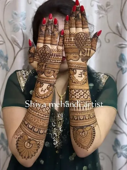 This design showcases the couple's initials 'S' and 'M' prominently on the back of the hands, surrounded by heart shapes and traditional patterns.
