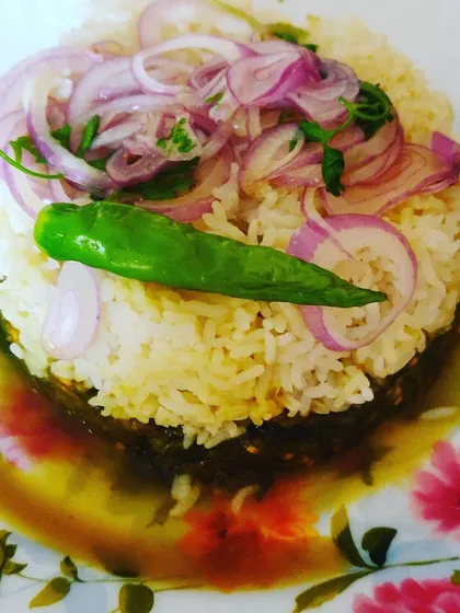 My special Bihari-style Palak Saag, a healthy spinach dish served over rice and topped with fresh onions and a green chili.