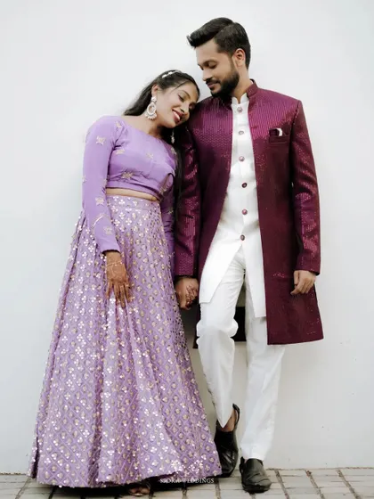 A sweet moment between the couple, the bride resting her head on the groom's shoulder, both dressed elegantly for their reception.