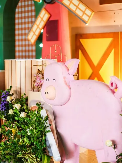 A playful pig prop adds a touch of fun to the barnyard scene. I use high-quality, life-sized props to make the theme feel real and exciting for the children.