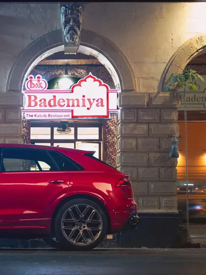 The night lights of our restaurant reflecting on a beautiful car. A perfect picture of class and taste.