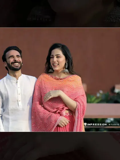Pure, unscripted laughter. This candid photo captures a lighthearted moment between the couple, showing that even in a formal shoot setting, the best pictures come from genuine happiness.