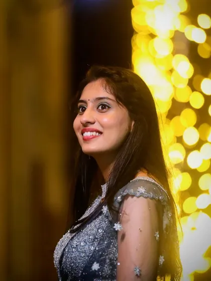 A soft glam look for a wedding guest. The makeup is paired with a modern embroidered gown, featuring a bright smile and glowing skin against a beautifully lit background.