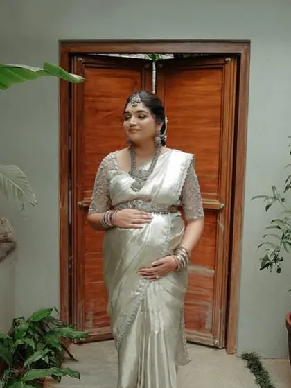 This client looks adorable in her silver saree for her Seemantham function. I designed a matching blouse with delicate embroidery to create a look of modern elegance.