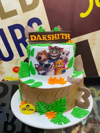 A 3kg Talking Tom and Friends cake set in a forest scene with a tree stump base.
