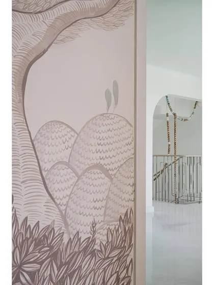 A hand-painted mural adds a touch of artistry to this hallway at Eden House, which leads out to a stunning staircase and outdoor area.