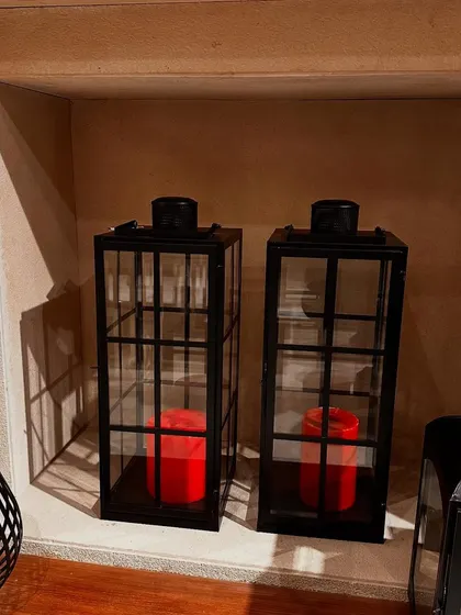 Our black metal lanterns are a versatile decor piece. For Christmas, I love filling them with bright red candles to create a classic holiday look.