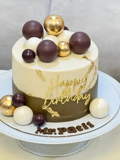 A full view of the modern olive green and ivory cake on a stand, personalized with "Mr. Patil" in chocolate. This shows how the design comes together for a sophisticated celebration.