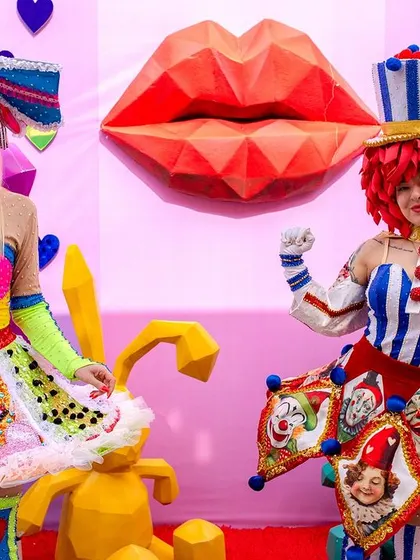Performers in whimsical, colorful costumes add to the theatrical and festive atmosphere of the Carnival party.