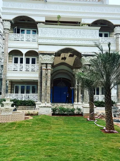 A grand residential project nearing completion. This shows the installation of the front lawn and a classical fountain, setting the stage for a magnificent entrance.
