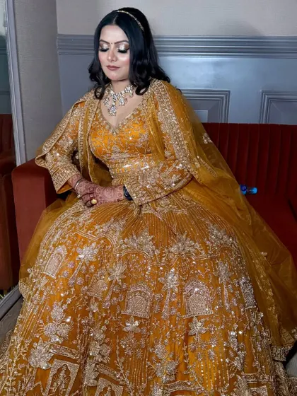 Another seated shot, capturing the full grandeur of her embroidered Anarkali and the elegance of her makeup.