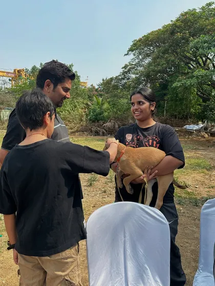 A potential adopter meets a gentle tan puppy at our Pawsome Heroes drive. These first interactions are so important. It's where families can feel a connection and see an animal's true personality shine.