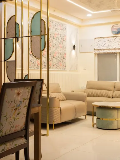 This view shows how the partition elegantly separates the living and dining zones. The floral wallpaper and marble-effect wall panels continue the theme of modern elegance.