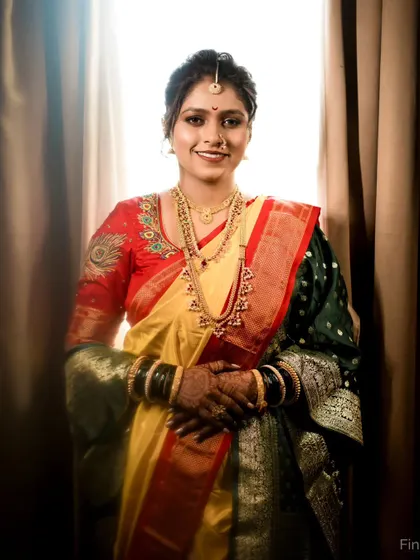 A confident and happy bridal portrait. The bride looks directly at the camera, showcasing her beautiful smile and the elegance of her Maharashtrian wedding attire.