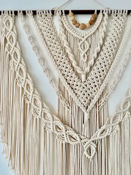 The flowing design of this V-shaped wall hanging is created with various macrame knots for a rich, textured look.