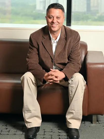 A full-length seated portrait that feels both relaxed and in control. This is a great alternative to a standard headshot for a more comprehensive professional profile.