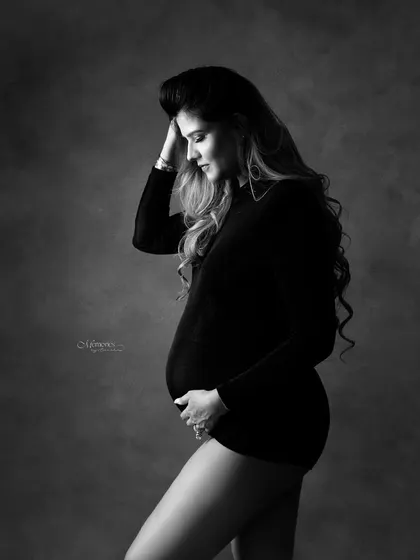 Grace in its purest form. This monochrome portrait focuses on the quiet, contemplative moments of pregnancy, highlighting the beauty of the female form.