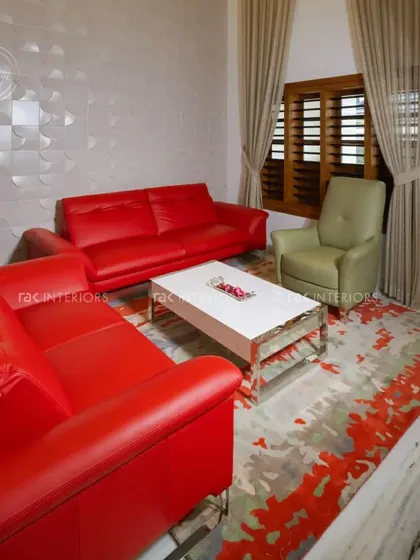 A bold living room design featuring bright red leather sofas. The 3D textured wall panel adds a modern, artistic element to the space, creating a high-impact look.