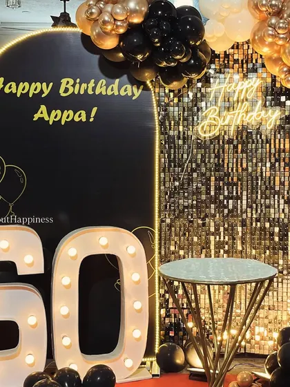 A close-up of our 60th birthday setup for 'Appa', featuring a sleek black arch, a shimmer wall, and bold light-up numbers.