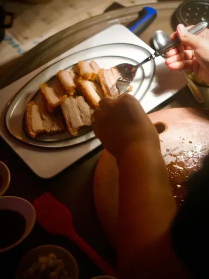 A guest enjoying a slice of our house-cured pork belly during a new menu tasting. It’s a moment of pure enjoyment and valuable feedback for our kitchen.