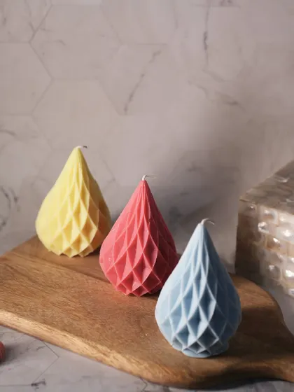 These geometric teardrop-shaped pillar candles come in a variety of colors. Their unique, faceted design makes them a modern and artistic decor accent.