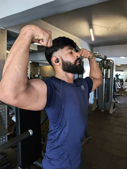 "Pain changes everything." A double bicep flex, showing how struggle can be transformed into physical strength.