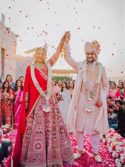 A triumphant moment for the couple after their Varmala, with the setting sun and a shower of petals.