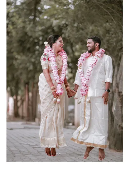 A happy, walking portrait of the couple after their Kerala wedding ceremony, their faces filled with smiles and love.