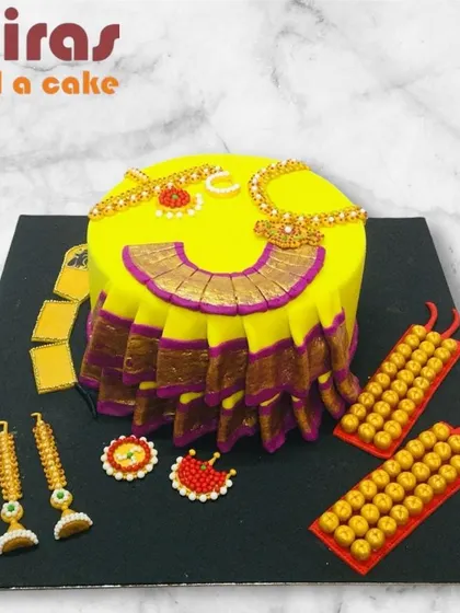 A cake celebrating the art of Bharatanatyam. This unique design is shaped like a dancer's costume and adorned with edible traditional jewelry, making it a beautiful tribute to the classical dance form.