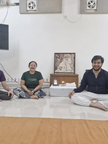 A small group smiles for a photo after a Surya Kriya session. The practice brings a sense of balance and joy, which is evident on their faces.