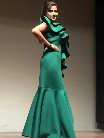 Make a statement in this emerald green mermaid gown with dramatic one-shoulder ruffle detail. This evening gown rental is ideal for formal events, award functions, or a glamorous cocktail night.