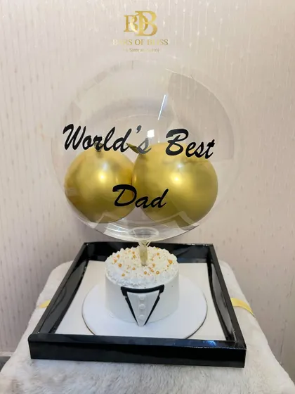 A sophisticated Father's Day gift featuring a tuxedo-themed bento cake and a "World's Best Dad" balloon display.