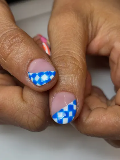 A close-up of the fun and fruity nails, showing the blue and white checkerboard pattern. It's a playful and eye-catching detail.