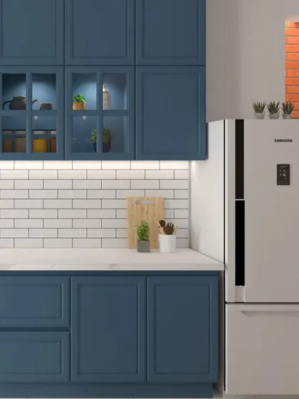 A classic kitchen design with deep blue shaker-style cabinets and a white subway tile backsplash. The glass-fronted upper cabinets with interior lighting add a decorative touch.