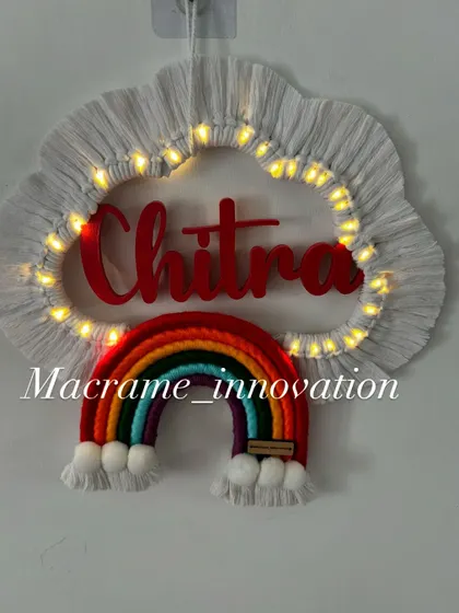 A custom name hanging for 'Chitra' glowing with warm fairy lights. The classic rainbow colors look so vibrant against the white cloud.