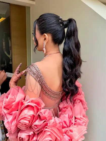 A chic and modern high ponytail with soft waves, perfect for a contemporary carnival or cocktail look.