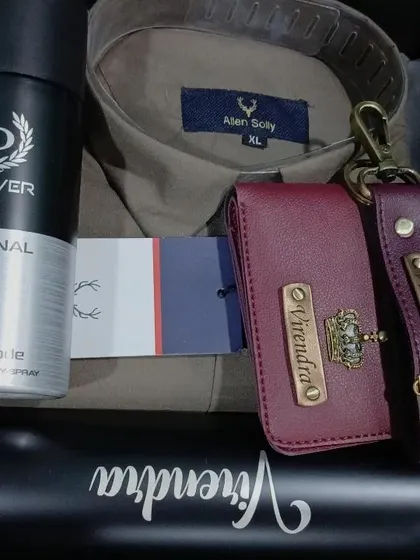 A sophisticated gift set with a personalized wallet and keychain, a name-engraved bottle, a shirt, and deodorant.