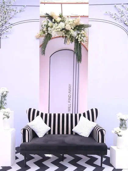 A chic black and white striped sofa set against a line-drawn architectural background, embodying the theme's minimalist sophistication.