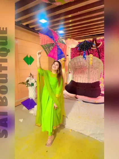 A green beauty celebrating Teej. This client looks lovely in a lime green Anarkali-style suit, holding a colorful umbrella to complete the festive look.