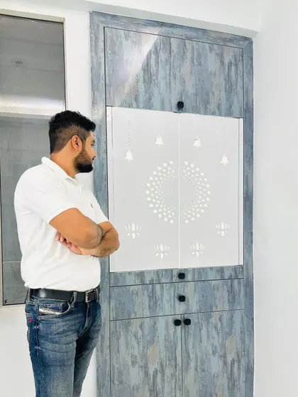 Another angle of our modern mandir design. This view shows the sleek, handleless design and the beautiful texture of the grey laminate, which contrasts nicely with the white backlit panel.