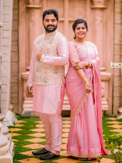 A classic, elegant portrait of a couple in matching pink traditional outfits. Their coordinated look is perfect for a timeless pre-wedding shoot.