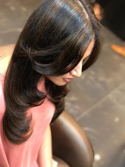 A beautiful example of a long layered haircut. The layers are feathered to create softness and movement, making the hair look full and dynamic.