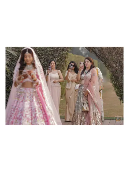 The bride's entry with her bridesmaids, who are capturing the moment on their own cameras. A fun, meta moment.