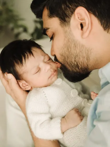 Another angle of a father's love, showing the delicate way he holds his sleeping baby.