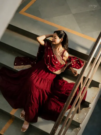 Using a staircase for a high-angle shot, this portrait emphasizes the beautiful flow and rich color of her maroon ethnic dress.