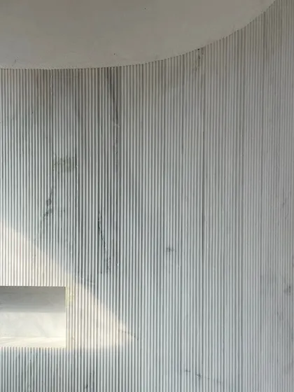 A play of materials at the House of Galleries. This fluted marble wall adds depth, texture, and character, with a built-in niche that catches the light.