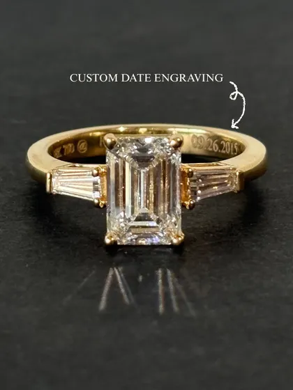 Some dates are not just remembered, they are felt. This emerald-cut solitaire ring holds a quiet detail, a custom date engraved inside the band. It is a memory set in gold, a story that begins on a day worth holding onto forever.