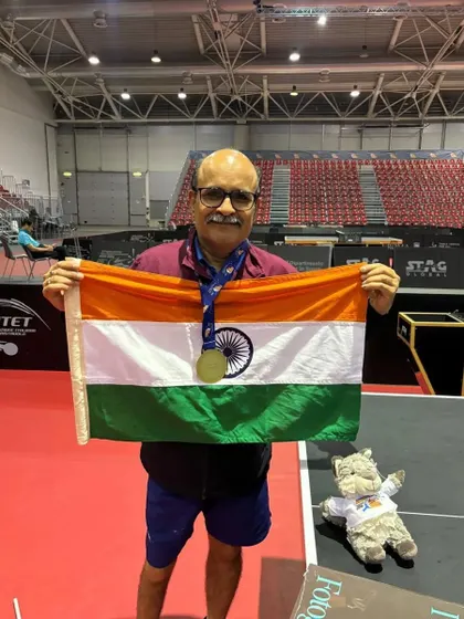 Gajanan Parmar proudly holds the Indian flag after his triumphant performance at the ITTF World Masters Championships, showcasing his gold medal.